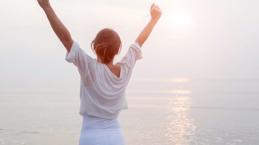 Woman embracing a sunset at the beach