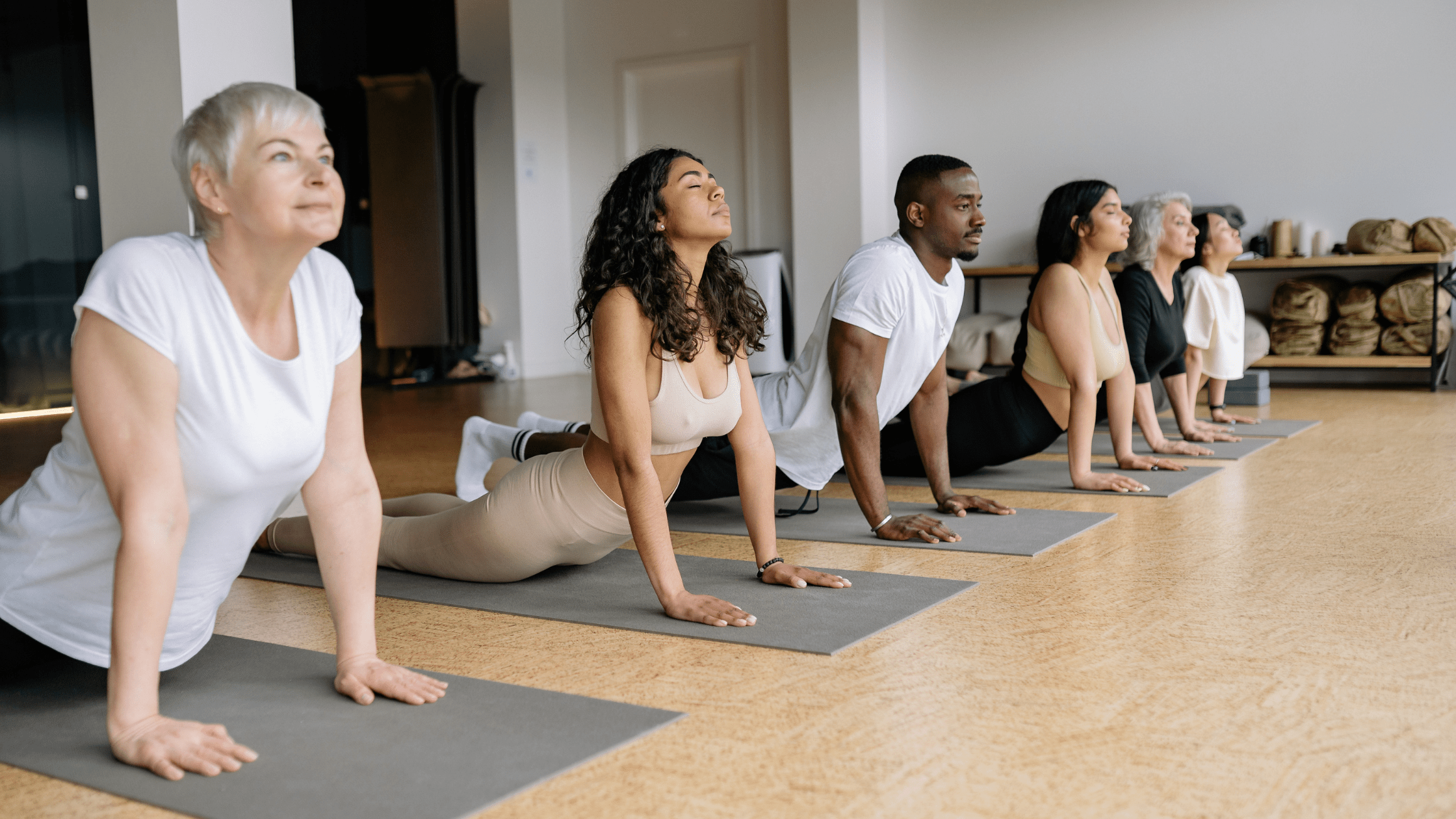 Mixed group of people practising yoga