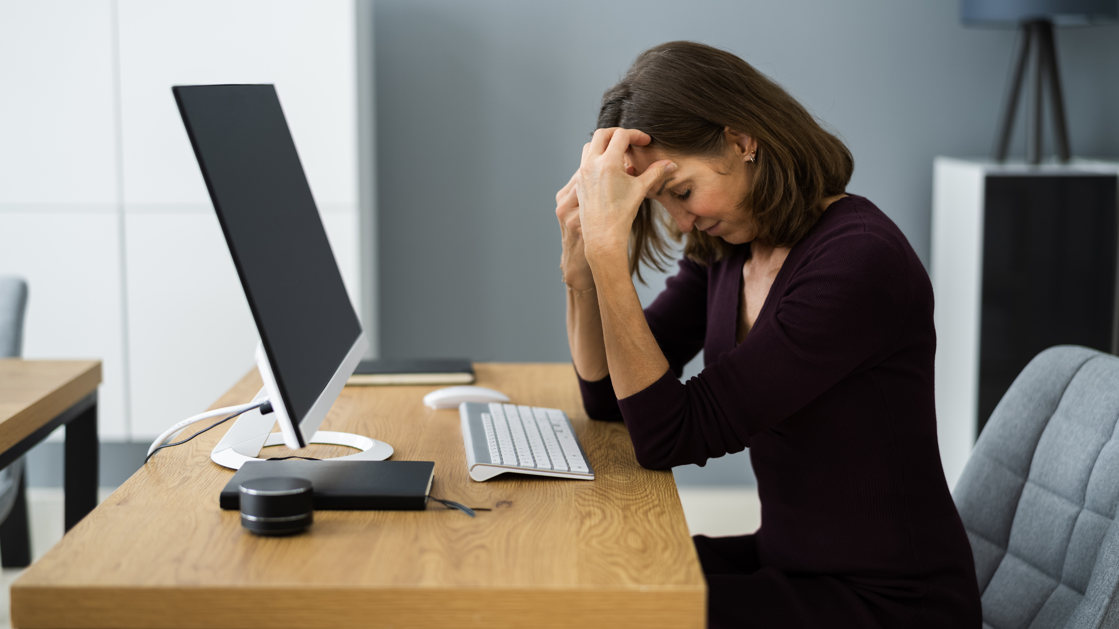A woman sitting at work with a computer at home with stress, Upset woman due to pregnancy related sickness Worried woman due to unfair treatment
